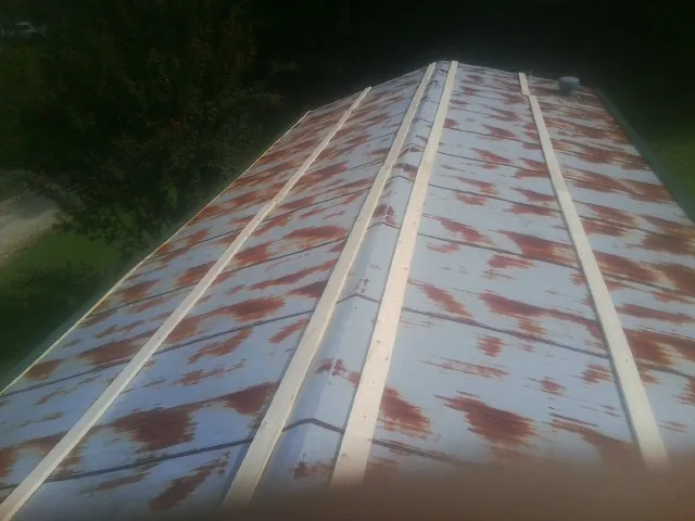 Rusted metal roof panels with new wood purlins before replacement — Storm Damage Roof Repair in New Richland by Roofing Brothers