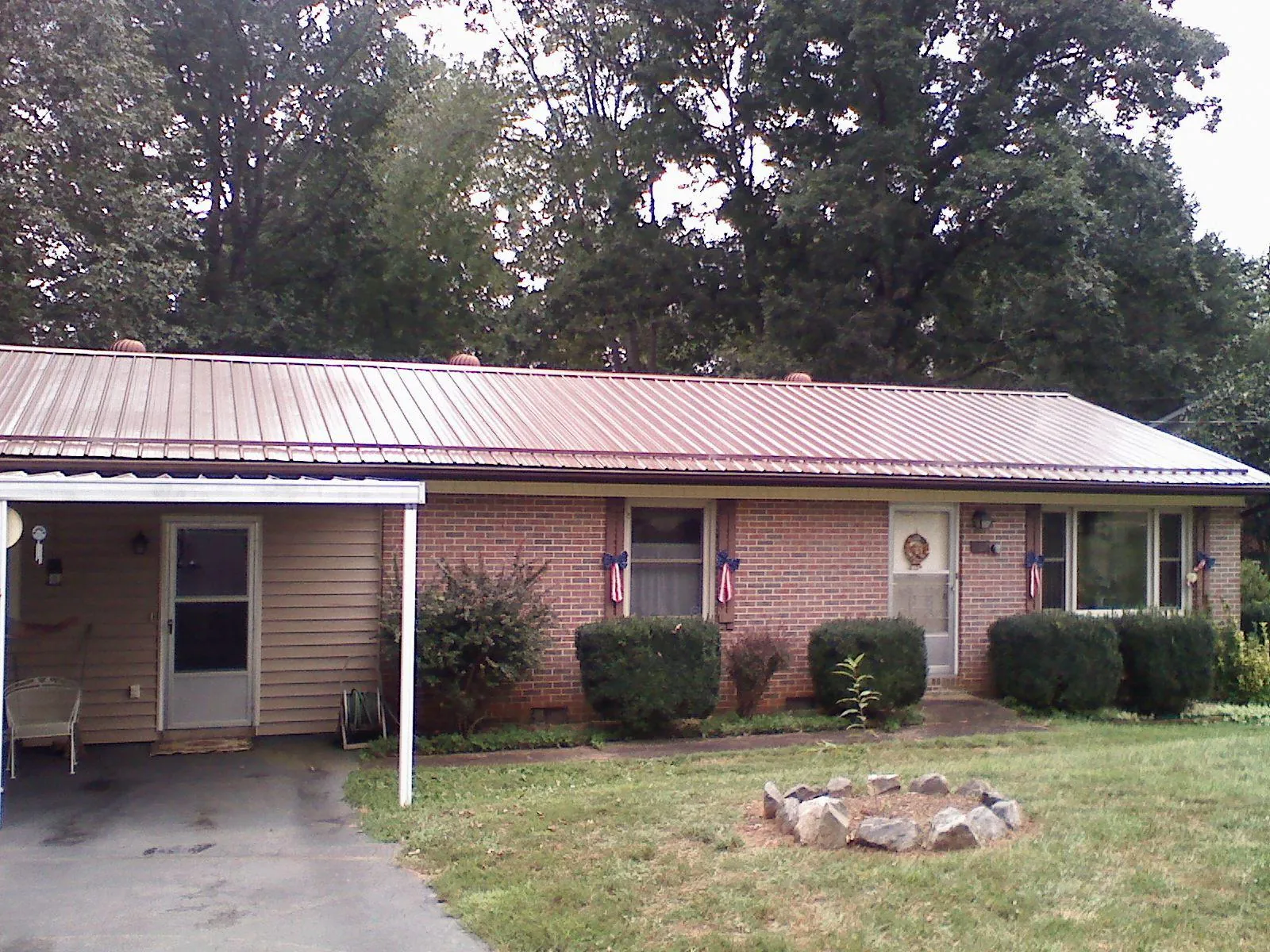 Bronze metal roof and carport on a brick ranch home — Roof Repair work by our crew in New Richland